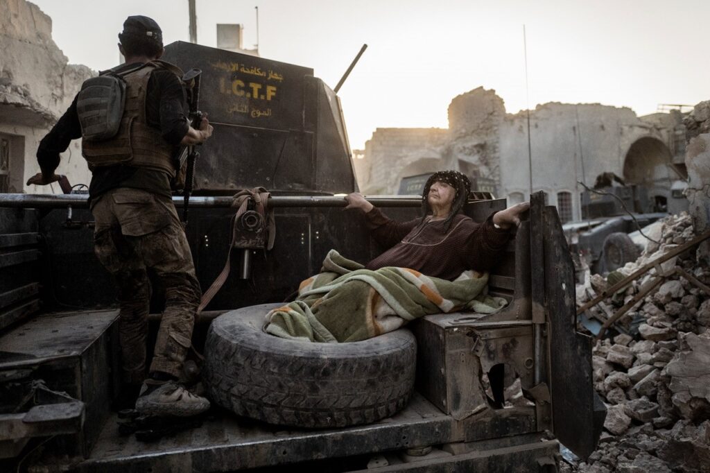En ældre dame bliver kørt gennem byen på ladet af en af Golden Divisions pansrede biler. Temperaturen nærmer sig 50 grader, og hun er for afkræftet til selv at komme væk fra kampzonen. 11 dage senere - 10. juli 2017 - erklærer den irakiske premierminister, Haider al-Abadi, at Mosul er befriet, selvom der stadig er spredte kampe rundt omkring i gaderne. Fotograf: Rasmus Flindt Pedersen